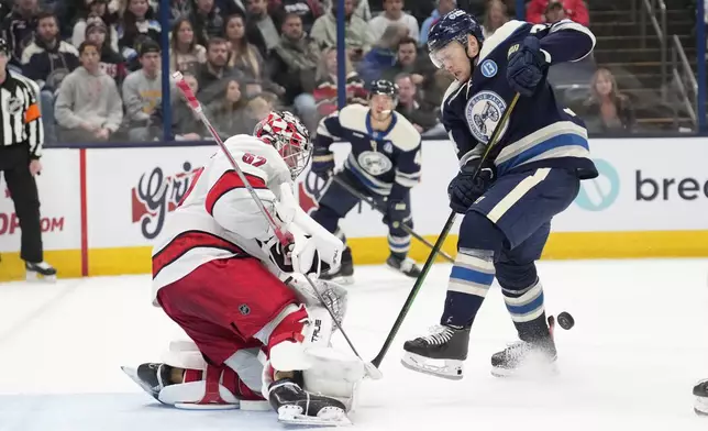 Carolina Hurricanes goaltender Pyotr Kochetkov blocks a shot by Columbus Blue Jackets right wing Mathieu Olivier, right, in the second period of an NHL hockey game in Columbus, Saturday, Nov. 23, 2024. (AP Photo/Sue Ogrocki)