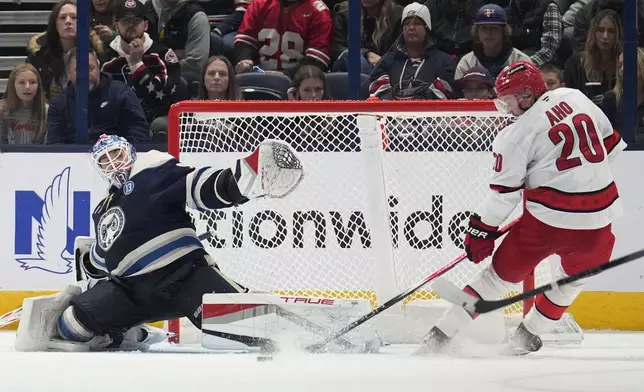 Columbus Blue Jackets goaltender Elvis Merzlikins blocks a shot by Carolina Hurricanes center Sebastian Aho (20) in the second period of an NHL hockey game in Columbus, Saturday, Nov. 23, 2024. (AP Photo/Sue Ogrocki)