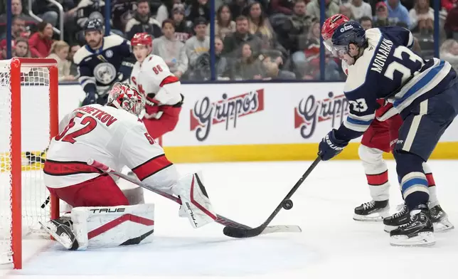 Carolina Hurricanes goaltender Pyotr Kochetkov (52) blocks a shot by Columbus Blue Jackets center Sean Monahan (23) in the second period of an NHL hockey game in Columbus, Saturday, Nov. 23, 2024. (AP Photo/Sue Ogrocki)