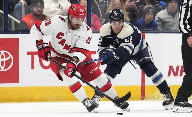 Carolina Hurricanes left wing William Carrier (28) controls the puck in front of Columbus Blue Jackets defenseman Jordan Harris (22) in the second period of an NHL hockey game in Columbus, Saturday, Nov. 23, 2024. (AP Photo/Sue Ogrocki)