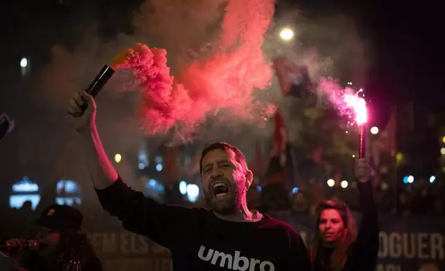 Demonstrators light flares while marching in a protest against the exorbitant rise in the price of renting an apartment in Barcelona, Spain, Saturday, Nov. 23, 2024. (AP Photo/Emilio Morenatti)