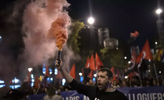 Demonstrators light flares while march in a protest against the exorbitant rise in the price of renting an apartment in Barcelona, Spain, Saturday, Nov. 23, 2024. (AP Photo/Emilio Morenatti)