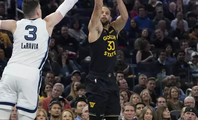 Golden State Warriors guard Stephen Curry, right, shoots a 3-point basket over Memphis Grizzlies forward Jake LaRavia during the first half of an Emirates NBA Cup basketball game Friday, Nov. 15, 2024, in San Francisco. (AP Photo/Godofredo A. Vásquez)