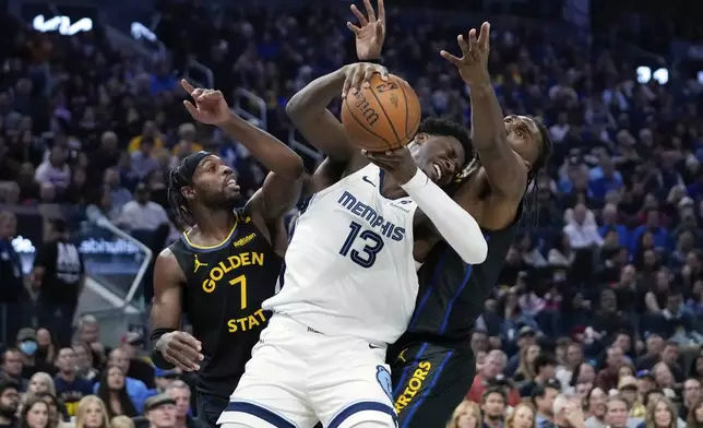 Memphis Grizzlies forward Jaren Jackson Jr. (13) and Golden State Warriors guard Buddy Hield, left, and center Kevon Looney compete for possession of the ball during the first half of an Emirates NBA Cup basketball game Friday, Nov. 15, 2024, in San Francisco. (AP Photo/Godofredo A. Vásquez)