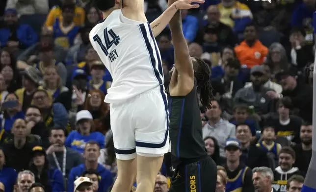 Memphis Grizzlies center Zach Edey (14) shoots over Golden State Warriors center Kevon Looney during the first half of an Emirates NBA Cup basketball game Friday, Nov. 15, 2024, in San Francisco. (AP Photo/Godofredo A. Vásquez)