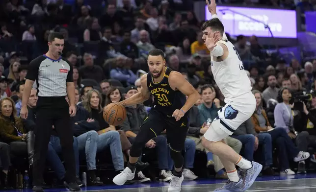 Golden State Warriors guard Stephen Curry (30) moves the ball while defended by Memphis Grizzlies forward Jake LaRavia during the first half of an Emirates NBA Cup basketball game Friday, Nov. 15, 2024, in San Francisco. (AP Photo/Godofredo A. Vásquez)