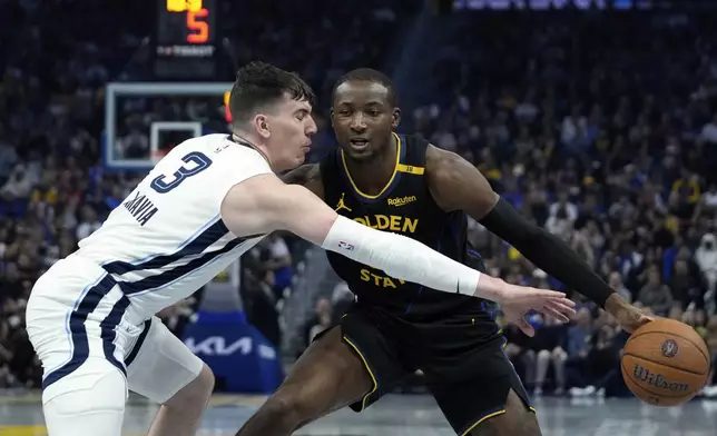 Memphis Grizzlies forward Jake LaRavia, left, tries to poke the ball away from Golden State Warriors forward Jonathan Kuminga during the first half of an Emirates NBA Cup basketball game Friday, Nov. 15, 2024, in San Francisco. (AP Photo/Godofredo A. Vásquez)