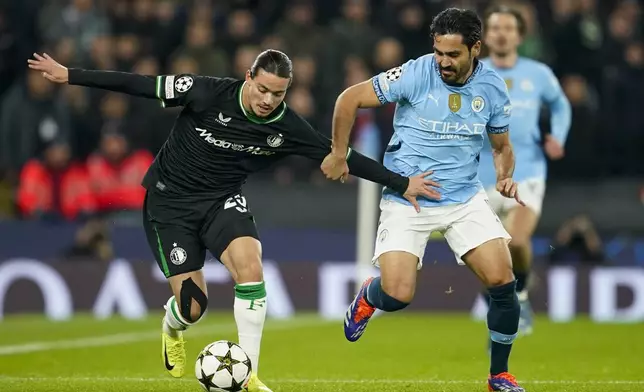 Feyenoord's Anis Hadj Moussa, left, and Manchester City's Ilkay Gundogan battle for the ball during the Champions League opening phase soccer match between Manchester City and Feyenoord at the Etihad Stadium in Manchester, England, Tuesday, Nov. 26, 2024. (AP Photo/Dave Thompson)