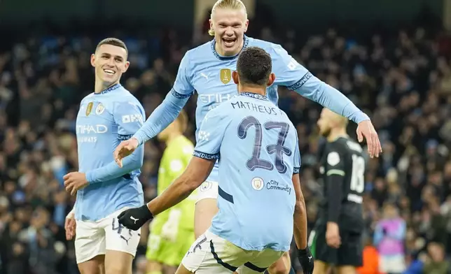 Manchester City's Erling Haaland, center, celebrates with Phil Foden, left, and Matheus Nunes after scoring his side's third goal during the Champions League opening phase soccer match between Manchester City and Feyenoord at the Etihad Stadium in Manchester, England, Tuesday, Nov. 26, 2024. (AP Photo/Dave Thompson)