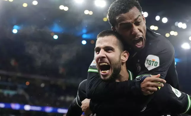 Feyenoord's David Hancko, left, celebrates after scoring his side's third goal during the Champions League opening phase soccer match between Manchester City and Feyenoord at the Etihad Stadium in Manchester, England, Tuesday, Nov. 26, 2024. (Potts/PA via AP)