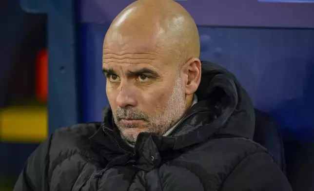 Manchester City's head coach Pep Guardiola takes his seat on the bench before the Champions League opening phase soccer match between Manchester City and Feyenoord at the Etihad Stadium in Manchester, England, Tuesday, Nov. 26, 2024. (AP Photo/Dave Thompson)