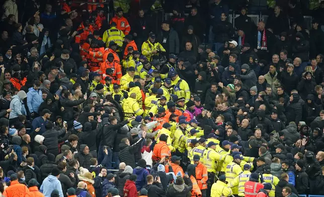 Police and stewards form a line to separate City and Feyenoord, right, fans during the Champions League opening phase soccer match between Manchester City and Feyenoord at the Etihad Stadium in Manchester, England, Tuesday, Nov. 26, 2024. (AP Photo/Dave Thompson)