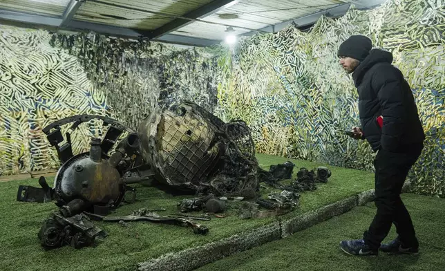 A journalist looks on fragments of a rocket which struck Dnipro on November 21, at a center for forensic analysis in undisclosed location, Ukraine, Sunday Nov. 24, 2024. (AP Photo/Evgeniy Maloletka)