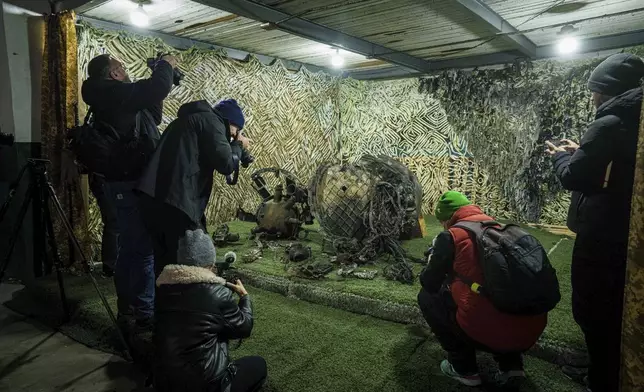 Journalists film fragments of a rocket which struck Dnipro on November 21, at a center for forensic analysis in undisclosed location, Ukraine, Sunday Nov. 24, 2024. (AP Photo/Evgeniy Maloletka)