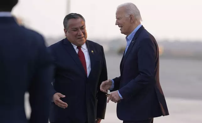 President Joe Biden greets Peru's Prime Minister Gustavo Adrianzen as he arrives at Jorge Chavez International Airport in Lima, Peru, Thursday, Nov. 14, 2024, to attend the APEC Summit. (AP Photo/Manuel Balce Ceneta)