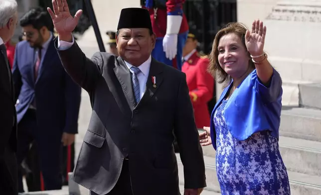 Indonesian President Prabowo Subianto, left, and Peru's President Dina Boluarte pose for photos on the steps of the government palace during a welcoming ceremony at the government palace in Lima, Peru, Thursday, Nov. 14, 2024, on the sidelines of the Asia-Pacific Economic Cooperation (APEC) summit. (AP Photo/Fernando Vergara)