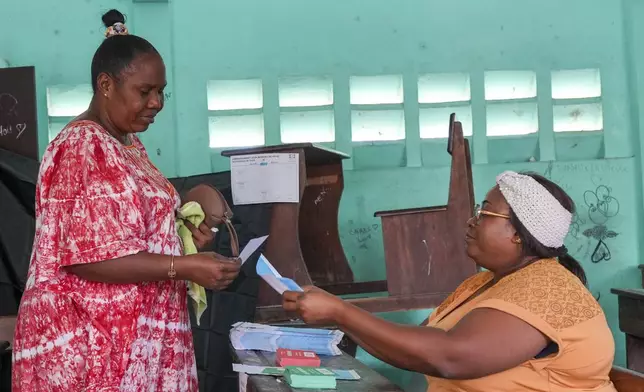 A woman votes in a referendum on whether to adopt a new constitution, in Libreville, Gabon, Saturday, Nov. 16, 2024. (AP Photo/Betines Makosso)