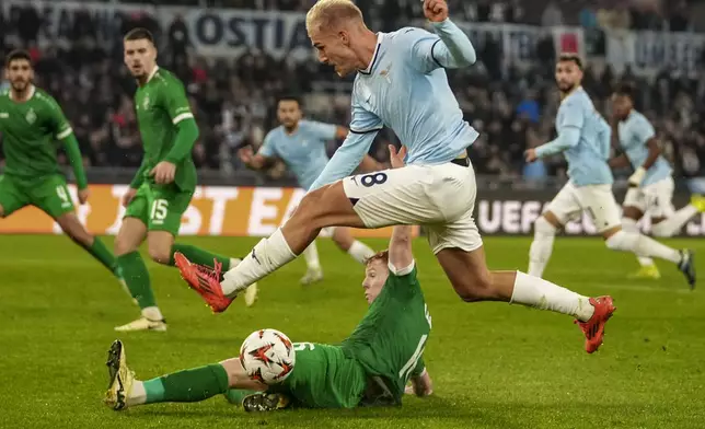 Lazio's Gustav Isaksen, top, and Ludogorets' Aslak Fonn Witry fight for the ball during an Europa League soccer match between Lazio and Ludogorets, at Rome's Olympic Stadium, Thursday, Nov. 28, 2024. (AP Photo/Andrew Medichini)