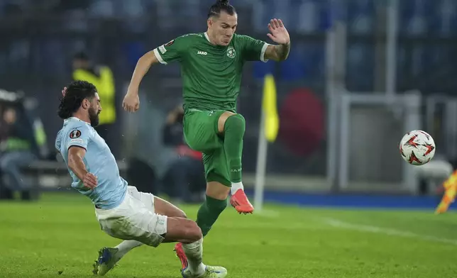 Lazio's Samuel Grigot, left, and Ludogorets' Son fight for the ball during an Europa League soccer match between Lazio and Ludogorets, at Rome's Olympic Stadium, Thursday, Nov. 28, 2024. (AP Photo/Andrew Medichini)