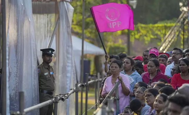 A woman holds a flag of Sri Lankan President Anura Kumara Dissanayake 's National People's Power party during a public rally ahead of Thursday's parliamentary election in Gampaha, Sri Lanka, Monday, Nov. 11, 2024. (AP Photo/Eranga Jayawardena)