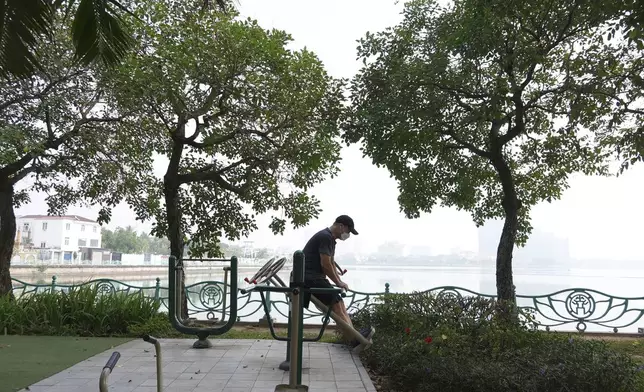 Nguyen Van Thai, wearing a face mask, exercises by the West Lake under a hazy sky in Hanoi, Vietnam on Thursday Nov. 14, 2024. (AP Photo/Hau Dinh)