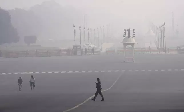 Commuters walk amidst a thick layer of smog in New Delhi, India, Thursday, Nov. 14, 2024. (AP Photo/Manish Swarup)