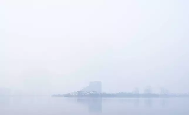 Thick smog hangs over West Lake in Hanoi blurring buildings in the distance, Thursday, Nov. 14, 2024. (AP Photo/Aniruddha Ghosal)