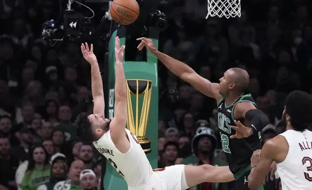 Cleveland Cavaliers guard Ty Jerome, left, tries to put up a shot against Boston Celtics center Al Horford, right, during the second half of an Emirates NBA Cup basketball game, Tuesday, Nov. 19, 2024, in Boston. (AP Photo/Charles Krupa)