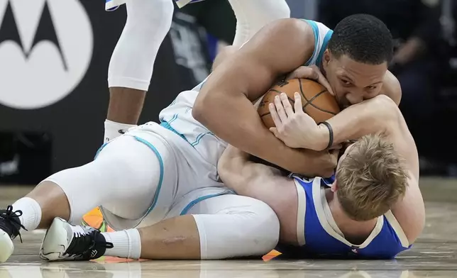 Charlotte Hornets' Grant Williams and Milwaukee Bucks' AJ Green go after a loose ball during the second half of an NBA basketball game Saturday, Nov. 23, 2024, in Milwaukee. The Bucks won 125-119. (AP Photo/Morry Gash)