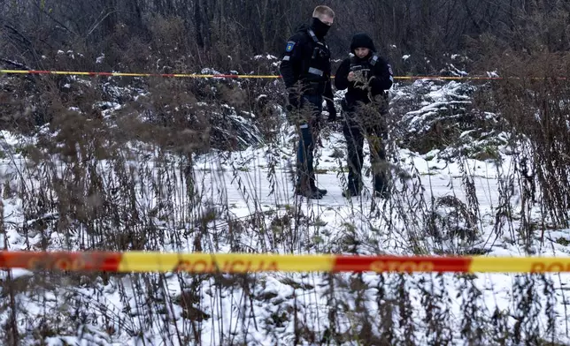 Police guard an area near the place where a DHL cargo plane crashed into a house near the Lithuanian capital Vilnius, Monday, Nov. 25, 2024. (AP Photo/Mindaugas Kulbis)