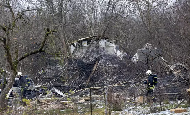 Lithuanian Emergency Ministry employees work near the site where a DHL cargo plane crashed into a house near the Lithuanian capital Vilnius, Lithuania, Lithuania, Monday, Nov. 25, 2024. (AP Photo/Mindaugas Kulbis)