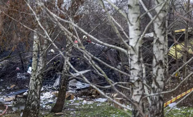 Lithuanian Emergency Ministry employees work near the site where a DHL cargo plane crashed into a house near the Lithuanian capital Vilnius, Lithuania, Lithuania, Monday, Nov. 25, 2024. (AP Photo/Mindaugas Kulbis)