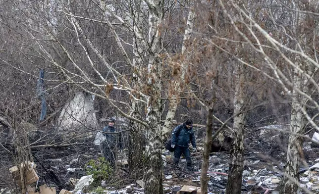 Lithuanian police investigators work near the site where a DHL cargo plane crashed into a house near the Lithuanian capital Vilnius, Lithuania, Lithuania, Monday, Nov. 25, 2024. (AP Photo/Mindaugas Kulbis)