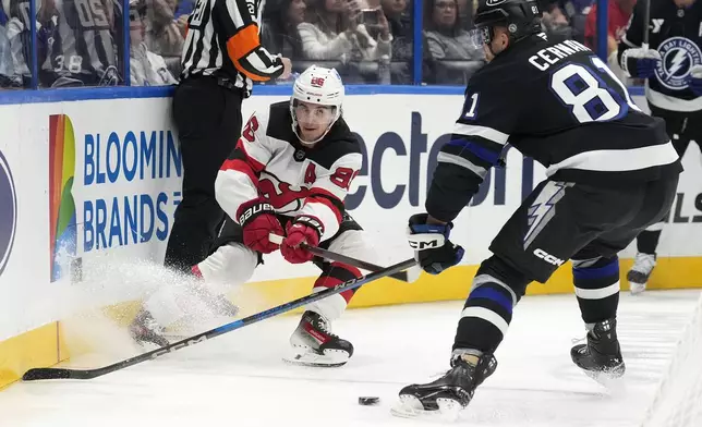 New Jersey Devils center Jack Hughes (86) slips the puck away from Tampa Bay Lightning defenseman Erik Cernak (81) during the first period of an NHL hockey game Saturday, Nov. 16, 2024, in Tampa, Fla. (AP Photo/Chris O'Meara)