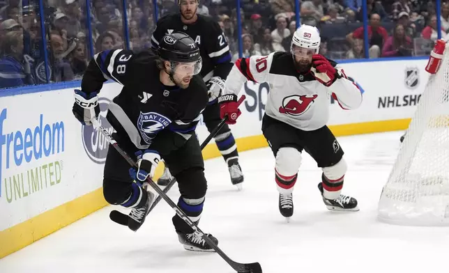 Tampa Bay Lightning left wing Brandon Hagel (38) breaks out ahead of New Jersey Devils left wing Tomas Tatar (90) during the first period of an NHL hockey game Saturday, Nov. 16, 2024, in Tampa, Fla. (AP Photo/Chris O'Meara)