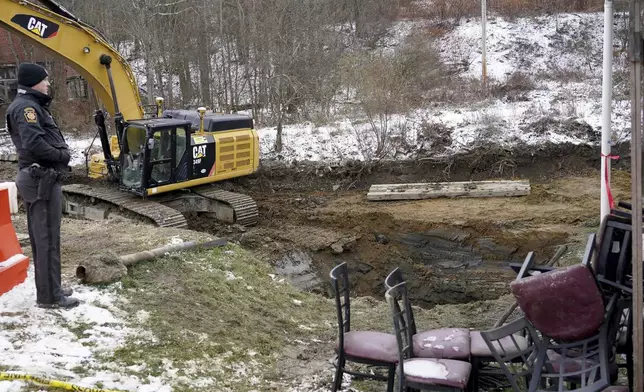 A Pennsylvania State Trooper looks over the sinkhole, where the remains of Elizabeth Pollard was found Friday, Dec. 6, 2024 in Marguerite, Pa. (AP Photo/Matt Freed)