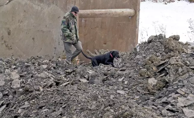 A rescue dog searches though debris that was removed from a sinkhole, Thursday, Dec. 5, 2024, where rescue workers believe Elizabeth Pollard disappeared into while looking for her cat, in Marguerite, Pa. (AP Photo/Matt Freed)