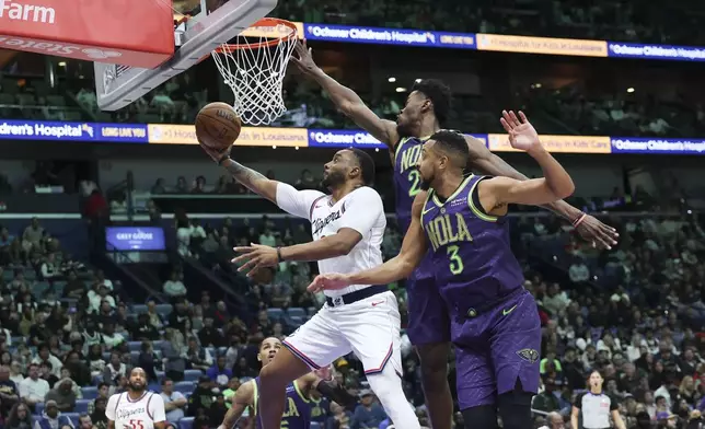 Los Angeles Clippers guard Norman Powell attempts a layup against New Orleans Pelicans forward Herbert Jones and guard CJ McCollum in the first half of an NBA basketball game in New Orleans, Monday, Dec. 30, 2024. (AP Photo/Peter Forest)