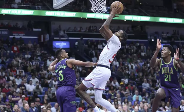 Los Angeles Clippers forward Derrick Jones Jr. attempts a layup against New Orleans Pelicans guard CJ McCollum (3) in the first half of an NBA basketball game in New Orleans, Monday, Dec. 30, 2024. (AP Photo/Peter Forest)