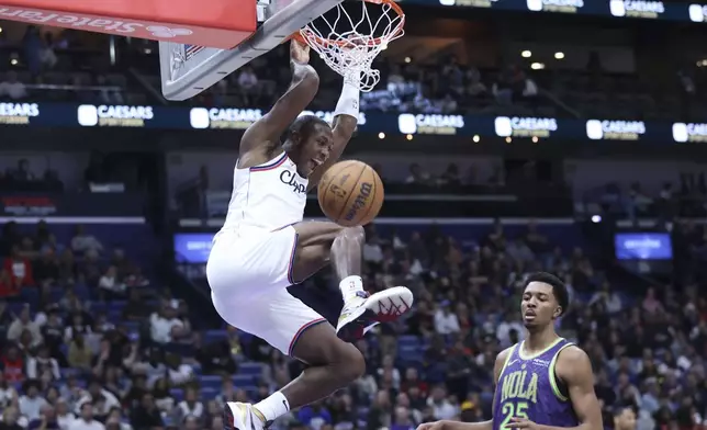 Los Angeles Clippers guard Kris Dunn (8) dunks past New Orleans Pelicans guard Trey Murphy III (25) in the first half of an NBA basketball game in New Orleans, Monday, Dec. 30, 2024. (AP Photo/Peter Forest)