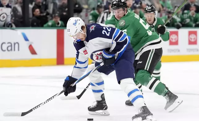 Winnipeg Jets center Mason Appleton (22) skates with the puck against Dallas Stars defenseman Nils Lundkvist (5) during the first period of an NHL hockey game Sunday, Dec. 1, 2024, in Dallas. (AP Photo/LM Otero)