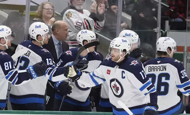 Winnipeg Jets center Adam Lowry (17) celebrates after his goal with teammates Gabriel Vilardi (13) and Kyle Connor (81) during the first period of an NHL hockey game against the Dallas Stars Sunday, Dec. 1, 2024, in Dallas. (AP Photo/LM Otero)