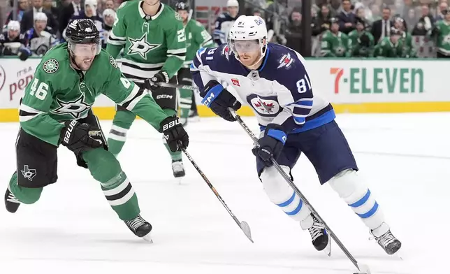 Winnipeg Jets left wing Kyle Connor (81) skates with the puck against Dallas Stars defenseman Ilya Lyubushkin (46) during the second period of an NHL hockey game Sunday, Dec. 1, 2024, in Dallas. (AP Photo/LM Otero)