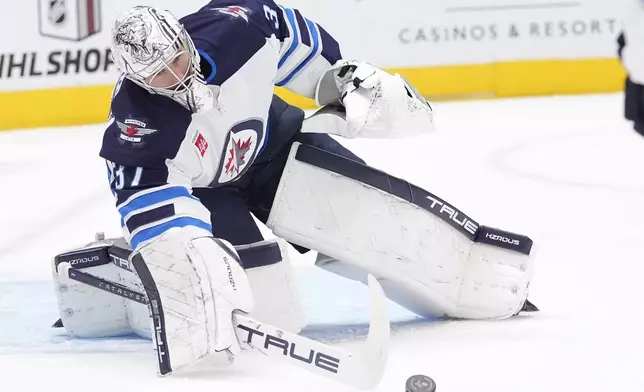 Winnipeg Jets goaltender Connor Hellebuyck (37) defends the goal during the first period of an NHL hockey game against the Dallas Stars, Sunday, Dec. 1, 2024, in Dallas. (AP Photo/LM Otero)