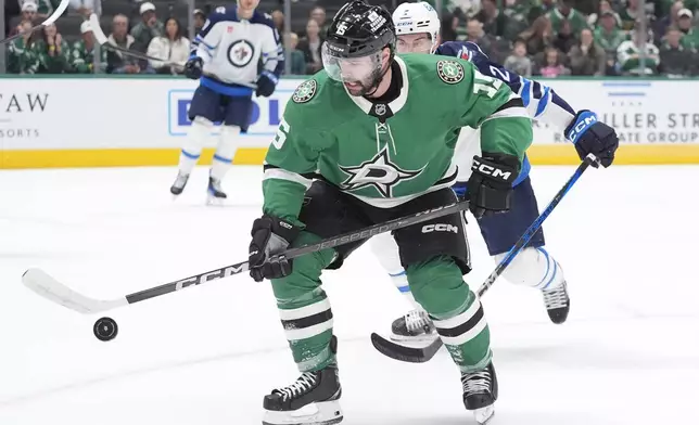 Dallas Stars center Colin Blackwell works the puck in front of Winnipeg Jets defenseman Dylan DeMelo during the first period of an NHL hockey game, Sunday, Dec. 1, 2024, in Dallas. (AP Photo/LM Otero)