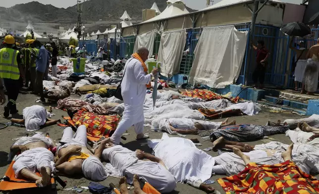 FILE - A muslim pilgrim walks through the site where dead bodies are gathered in Mina, Saudi Arabia during the annual hajj pilgrimage, Thursday, Sept. 24, 2015. (AP Photo, File)