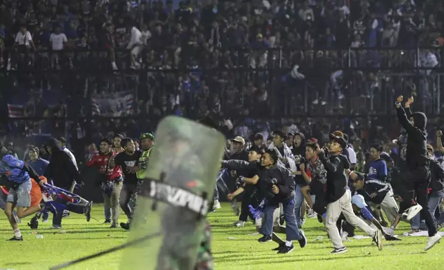 FILE - Soccer fans enter the pitch during a clash between supporters at Kanjuruhan Stadium in Malang, East Java, Indonesia, Saturday, Oct. 1, 2022. (AP Photo/Yudha Prabowo, File)