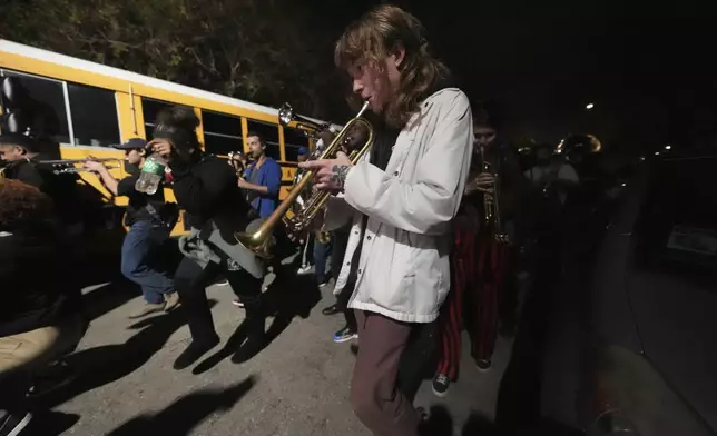 Musicians and friends form a second line parade organized by Orlando Prince, a rising jazz musician, for his father John "Prince" Gilbert, as a sendoff for his father who recently died, in the Treme section of New Orleans, Monday, Dec. 16, 2024. (AP Photo/Gerald Herbert)