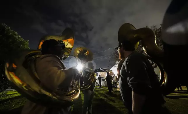 Musicians and friends form a second line parade organized by Orlando Prince, a rising jazz musician, for his father John "Prince" Gilbert, as a sendoff for his father who recently died, in the Treme section of New Orleans, Monday, Dec. 16, 2024. John "Prince " Gilbert was a founding member of the Rebirth Brass Band and a fixture in the New Orleans Jazz community for decades. (AP Photo/Gerald Herbert)