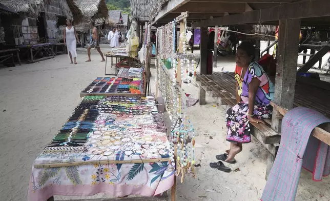 Bon Klathale wait for customers to sell souvenirs at Moken village at Surin Islands in Phang Nga Province, Thailand, Wednesday, Dec. 11, 2024. (AP Photo/Sakchai Lalit)